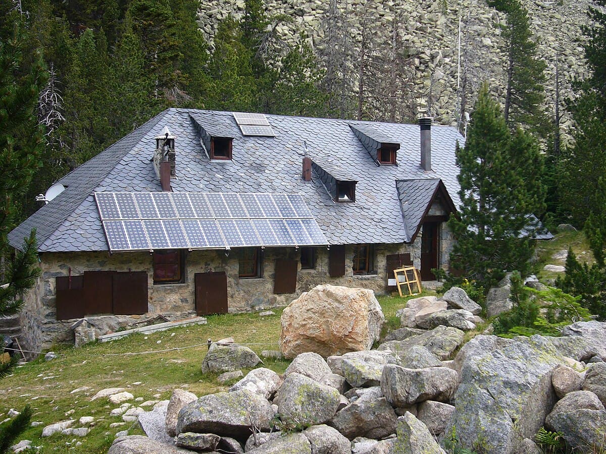 Refugi d'Estany Llong stone mountain refuge with solar panels on slate roof