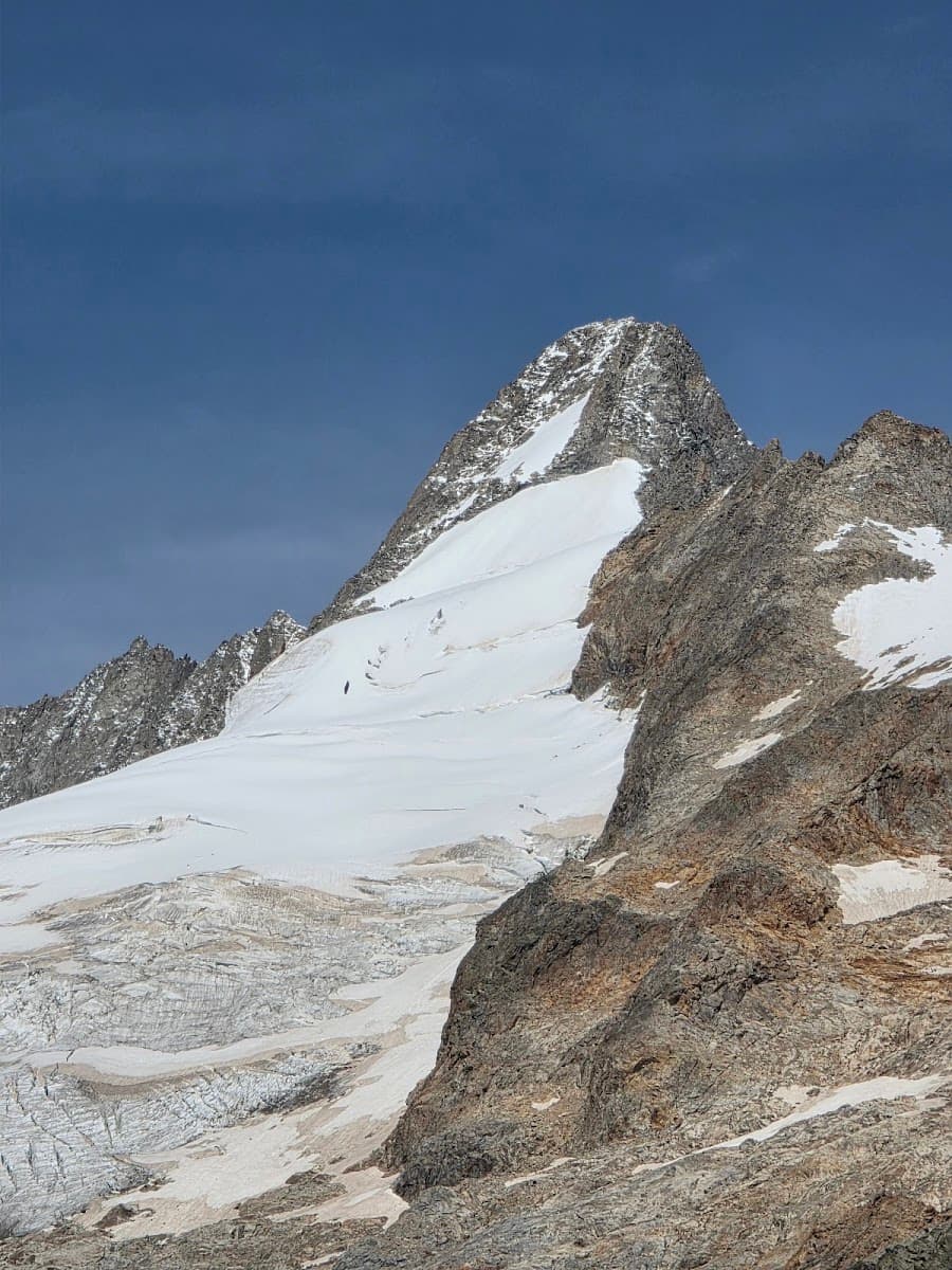 Snow-capped mountain peak with glacier ice against a clear blue sky