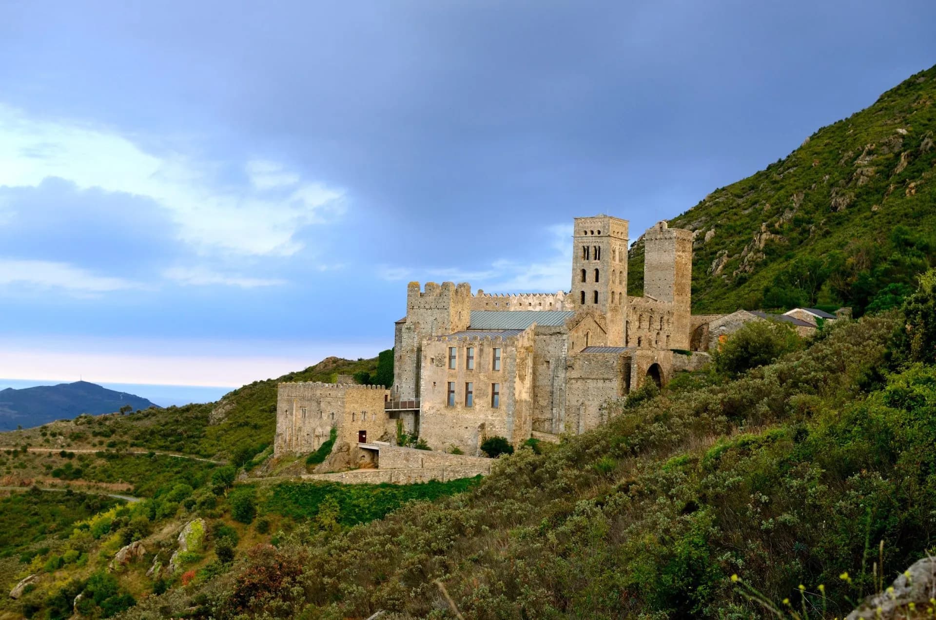 Sant Pere de Rodes monastery built into a steep hillside overlooking the Mediterranean Sea.